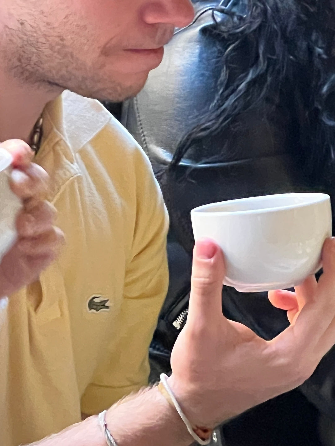 Persona disfrutando una taza de café blanco en una sesión de degustación y taller de café especialidad